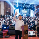Ketua Umum Laskar Gibran Leonardo Pandapotan Sirait saat memberikan pidato pengukuhan relawan di podium.